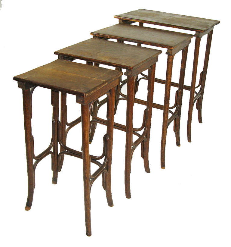 Each table in this very functional set of graduated side tables has an oak top and a bentwood base. The smallest table top is 12