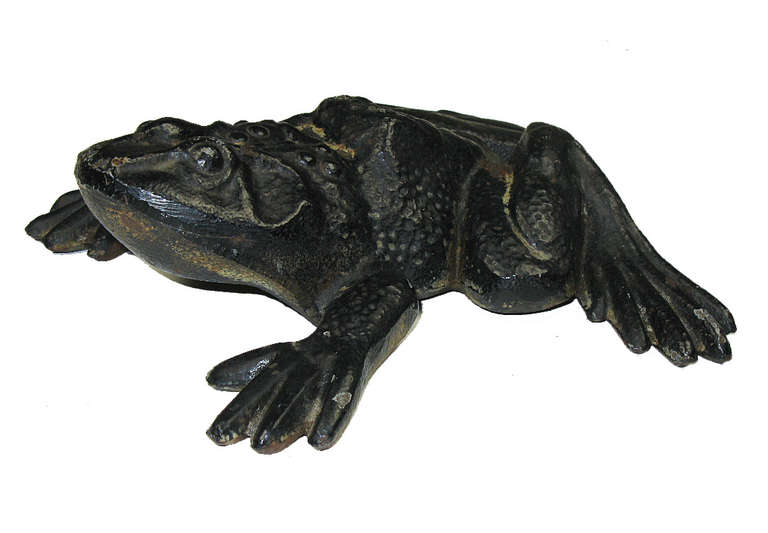 This frog which is poised to leap, is cast iron in black paint and has minimal rust.Â It is a good, larger form frog that is useful as a doorstop, paper weight or fun ornament.