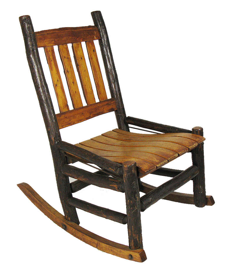 These classic rustic porch rocking chairs have bark-on cedar pole frames, live-edge cedar plank backs, and birch plank seats. These were most likely made by one of the early 20th century New Jersey manufacturers of Atlantic white cedar furniture