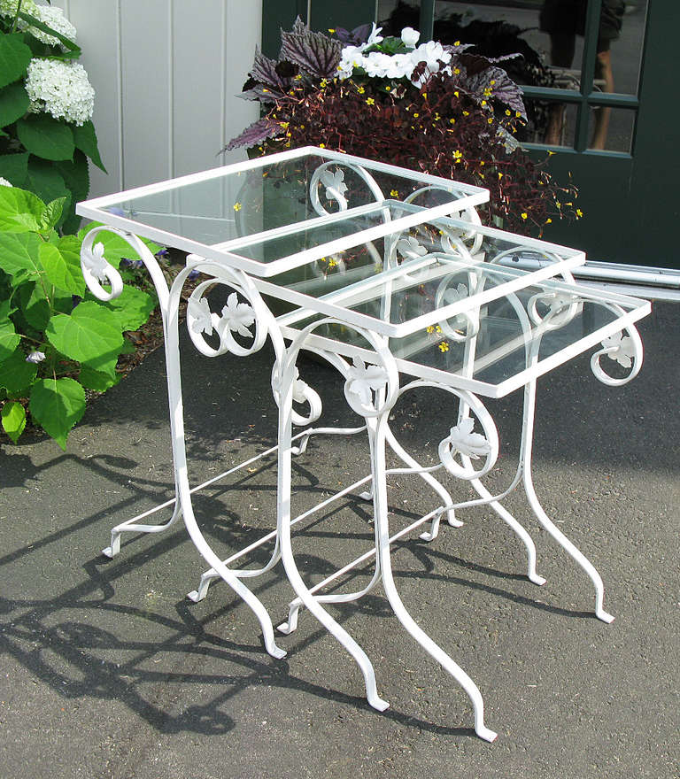 These three wrought iron tables nest to use as one, or pull apart to become three side tables. They have glass tops and an ivy leaf design, and were most likely made by Salterini or Woodard.