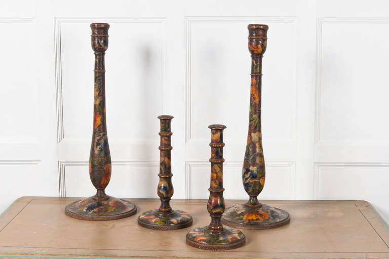 Two pairs of early 20th century candlesticks with pyrography decoration