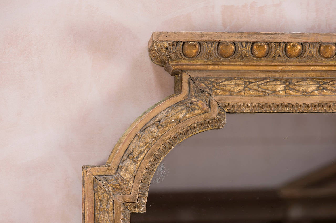 A large elegant giltwood overmantle mirror, with composite decoration. Having its original soft gilding, circa 1860