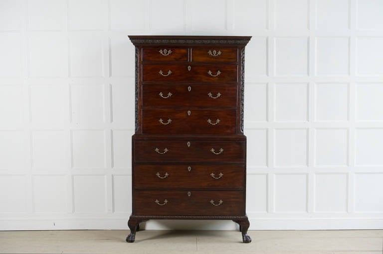 A rare late George II mahogany tallboy. The dentil cornice carved with flower and dart decoration, having acanthus clasped corners. The top half with fluted canted corners, surmounted with carved trailing flowers . The base moulding carved with egg