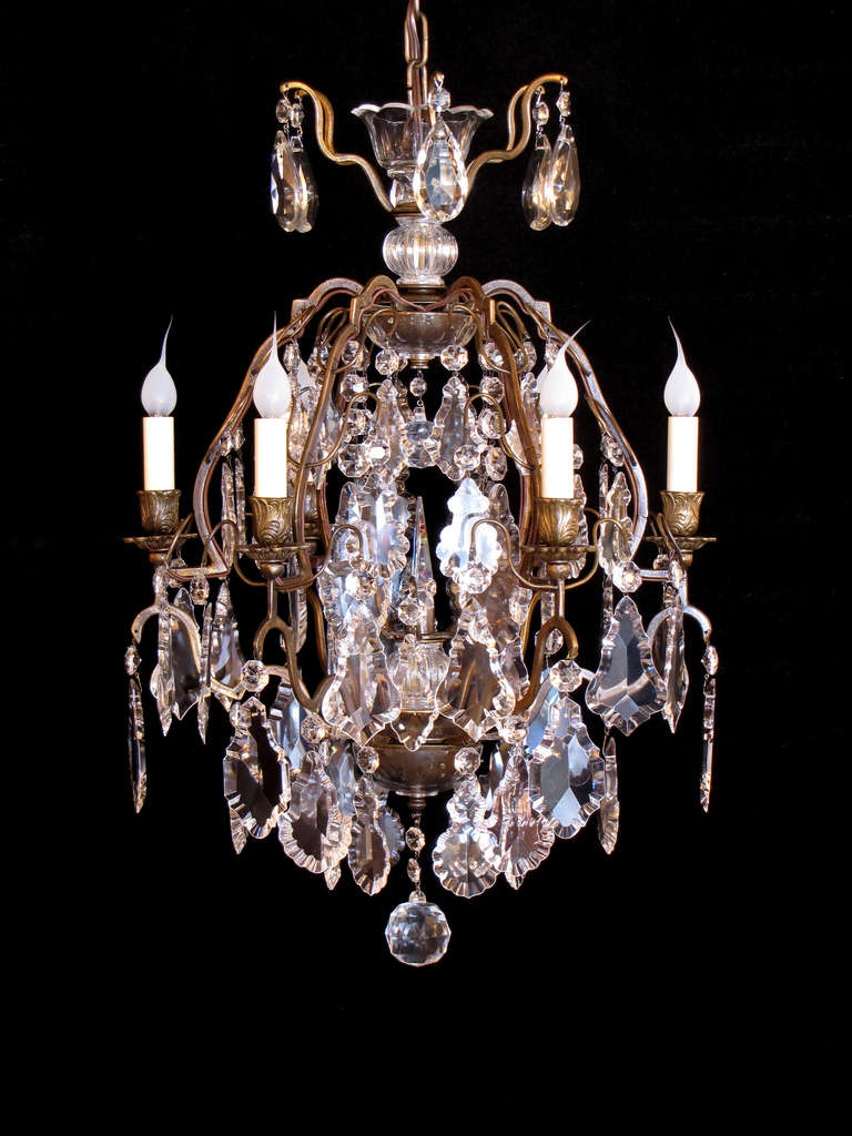 This is a pair of small French bronze and crystal Louis XV style chandeliers with large flat Czechoslovakian pendeloque crystals. The frames are made of a patinated bronze.