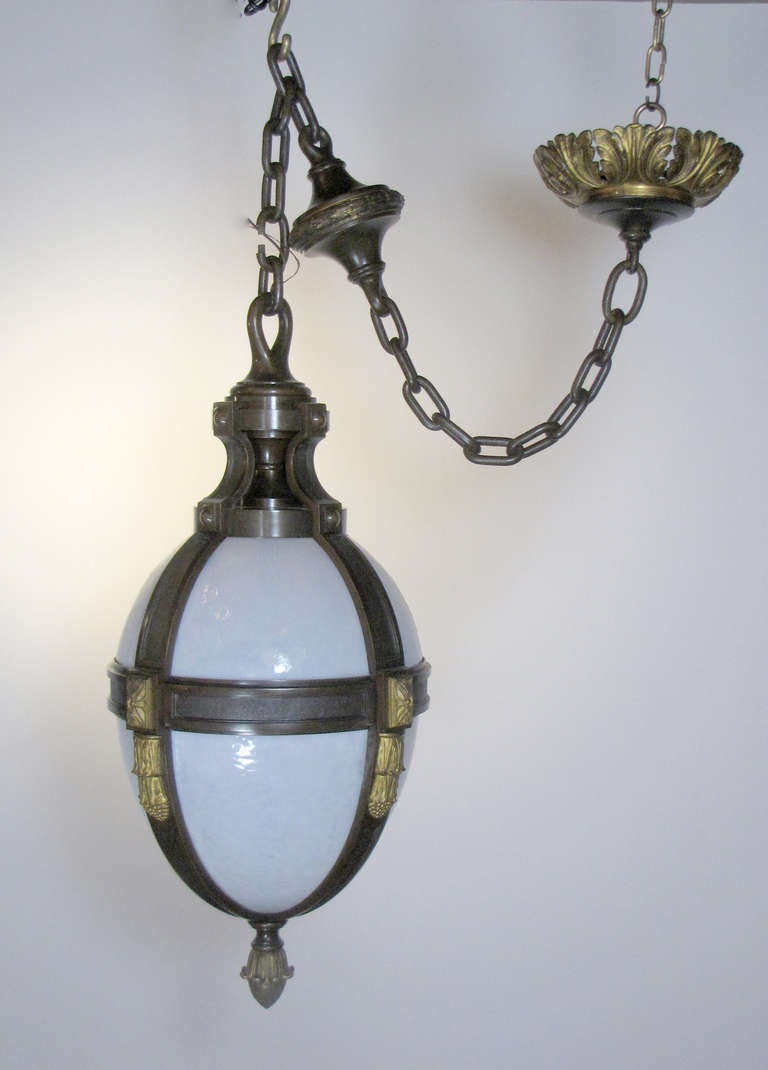 This is a Federal style pendant lantern with opalescent glass and patinated bronze with gilt bronze details. It is attributed to E. F. Caldwell & Co.  This fixture has the original chain and canopy.  The height includes chain.  Without chain, the