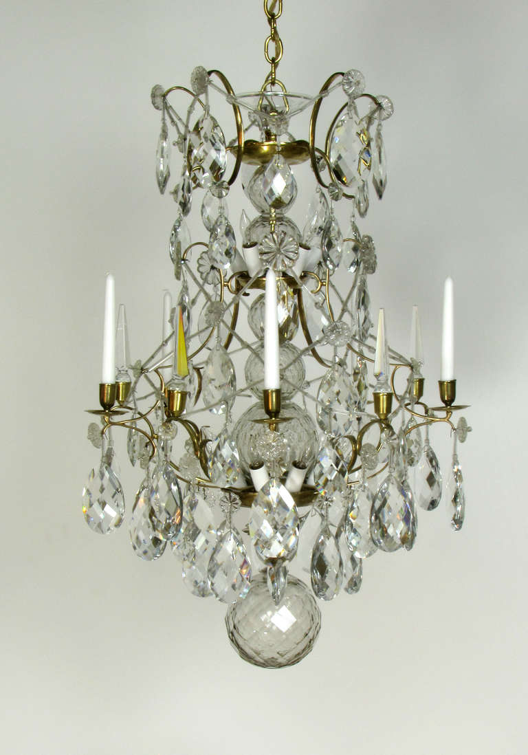 This is a unique bronze and crystal chandelier with a cage shaped frame. Glass straws are strung crisscrossing the frame. The center stem has three cut crystal balls in increasing size, with a large cut crystal bottom ball. The crystal balls have a