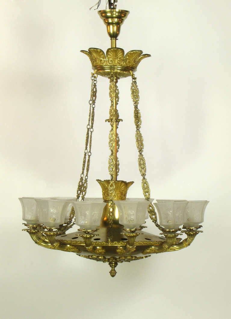 This is an imposing twelve light chandelier originally gas.   It is made of bronze with finely cast gilt bronze ornamentation.