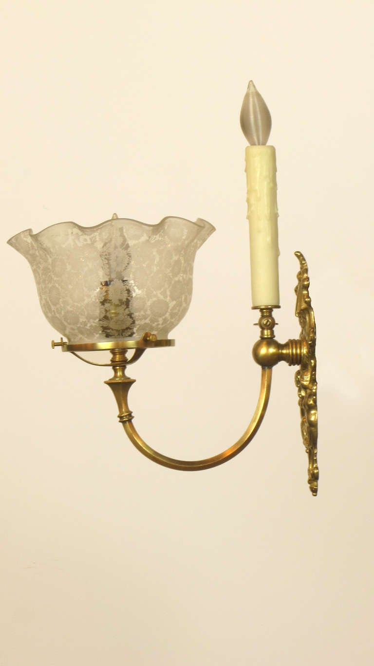 This is a pair of sconces from the transitional period, originally with both a gas jet and an electric light. The sconces are sold with glass from the period.  They are fully wired.
