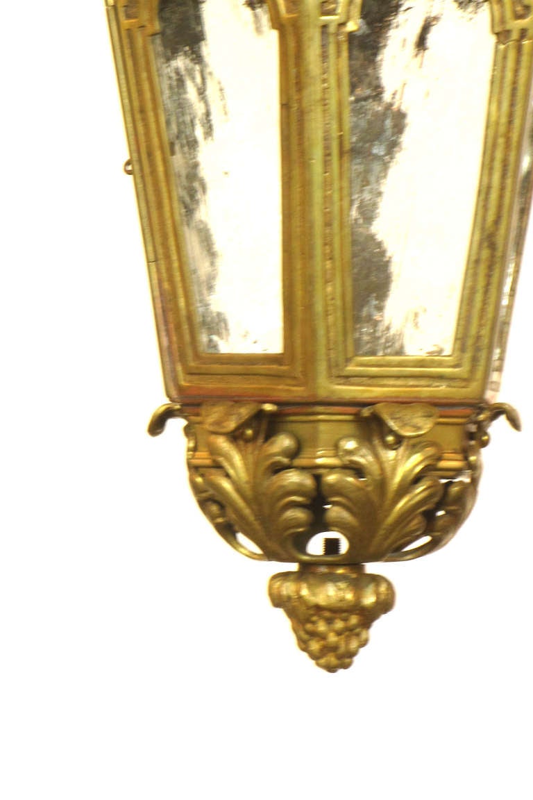 A bronze lantern with Acanthus leaf metalwork forming the top and bottom.  There are six panes of textured glass.  One of the six sides has a latching door for access to the single light bulb.