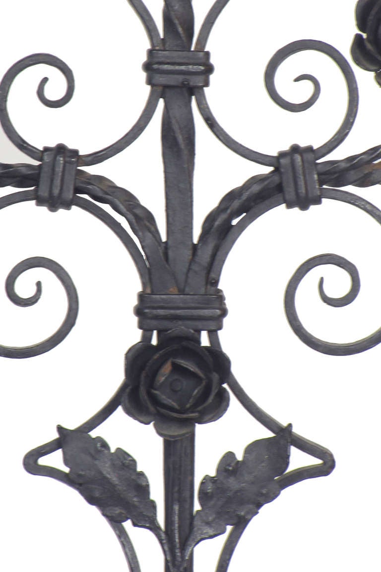 Decorated with roses and delicate iron scrollwork, this is a freestanding candelabra that can hold three candles.  the iron is in excellent condition with minor areas of patina.  It is not electrified, but can be electrified to the specifications of