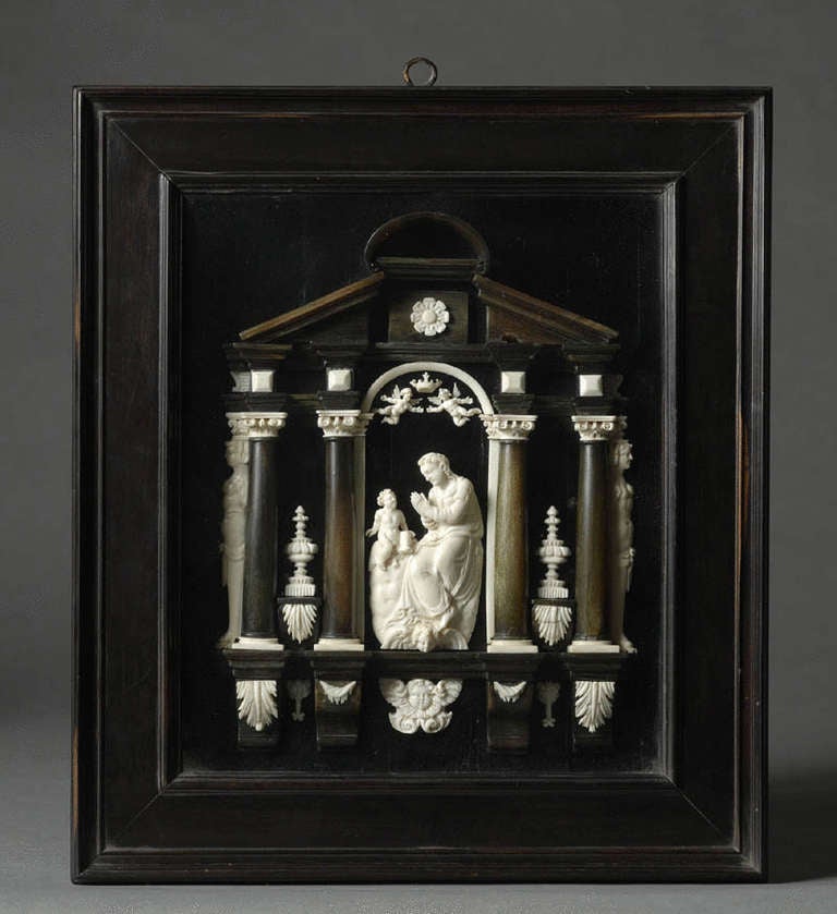 Ivory and ebonised relief of the Madonna and Child within an architectural altar and mounted in a deep glazed frame. South Italian or Sicilian, 18th Century. Inscribed on paper label on reverse: ‘Ivoir Provenant de Couvent de la Visitation de Romans