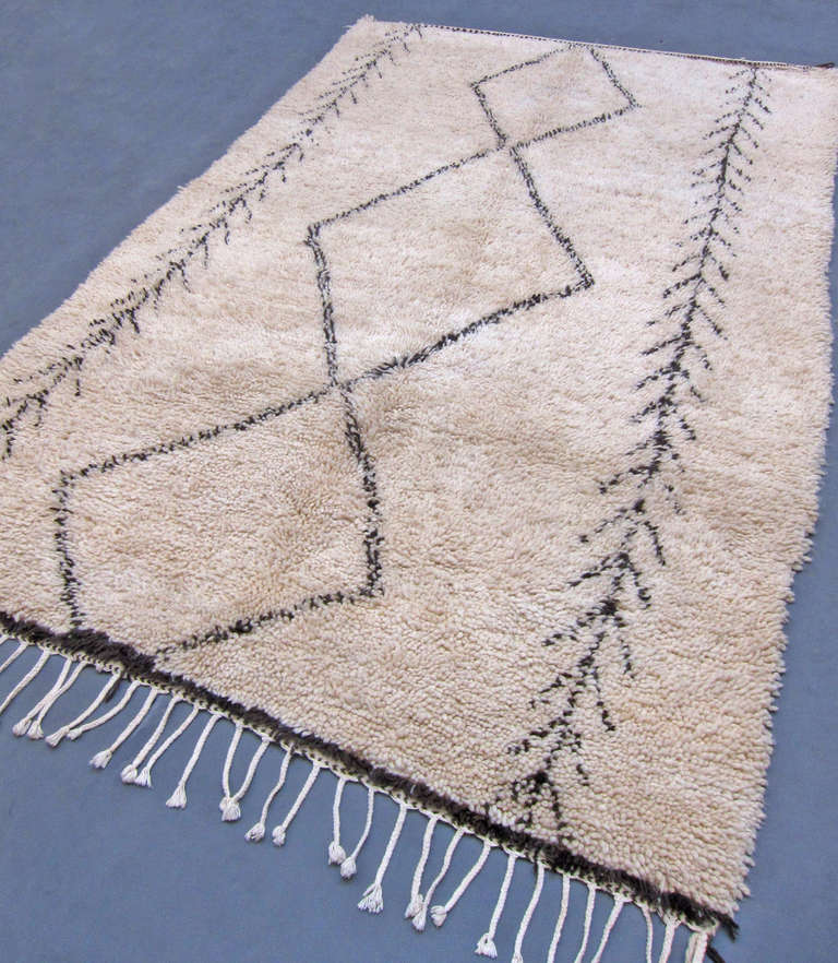 Berber Beni Ouarain pile rug with a paired down design of three lozenges sided by two chevron lines.