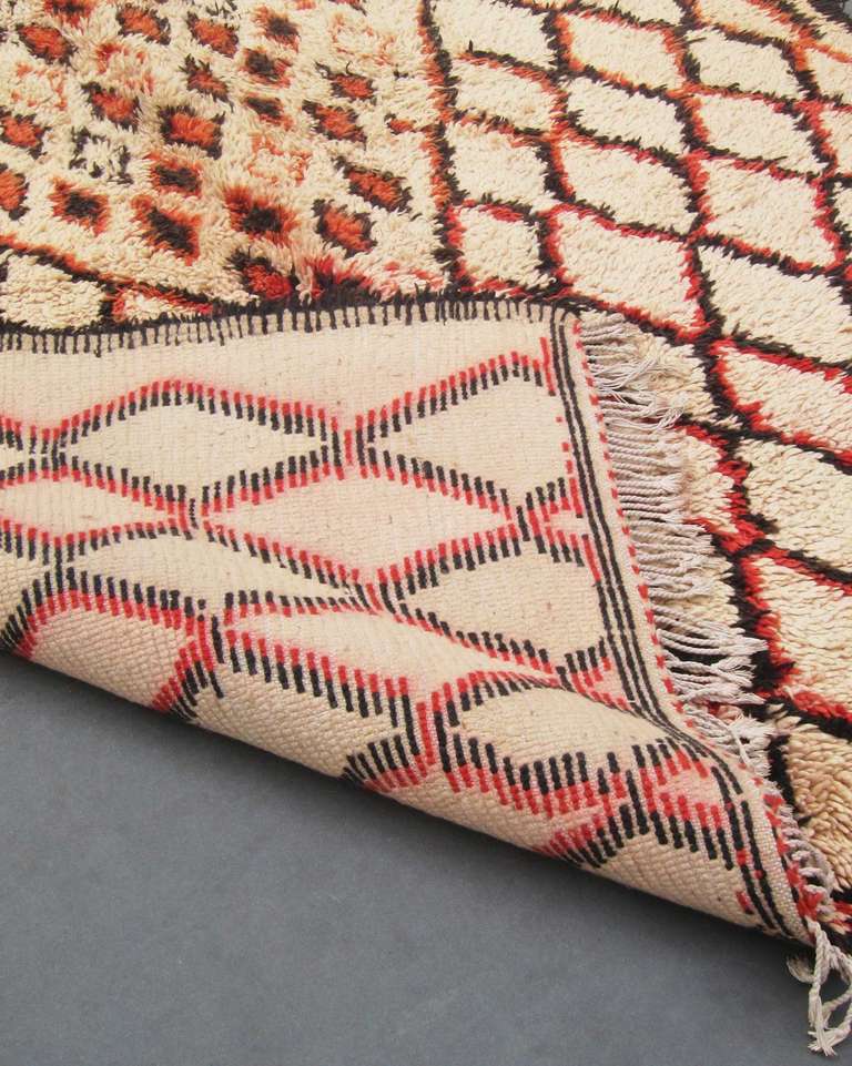 Rare Beni Ourarain rug with prominent lozenges in dark brown and orange-red with a central medallion containing smaller diamonds.