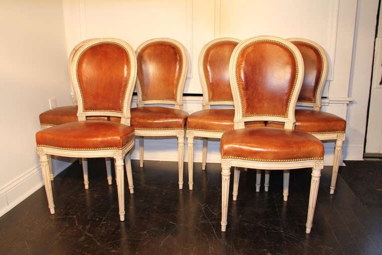 Set of 6 Round Back Fauteuil Chairs with cognac leather and a nailhead trim. Antiqued off-white finished wooden frames.