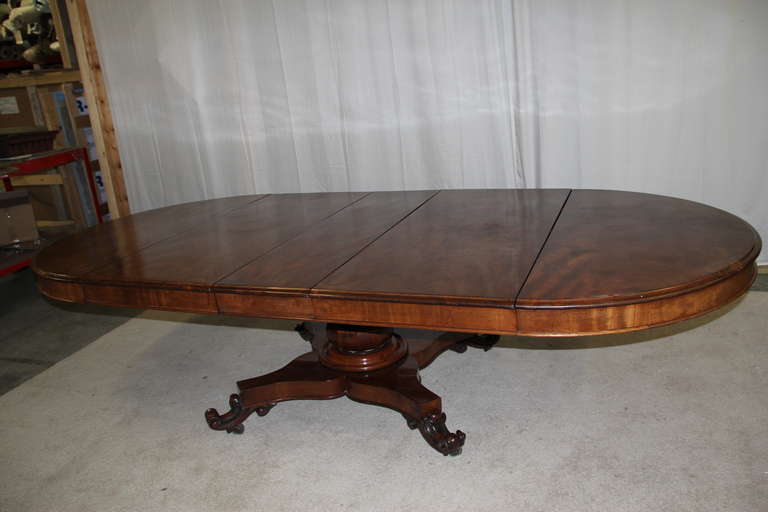 Extendable mahogany pedestal dining table from the William IV period. Circular top opens to receive three original leaves. Supported on bearers above a baluster column, platform and four carved scroll feet. This table was purchased from Julian Bly