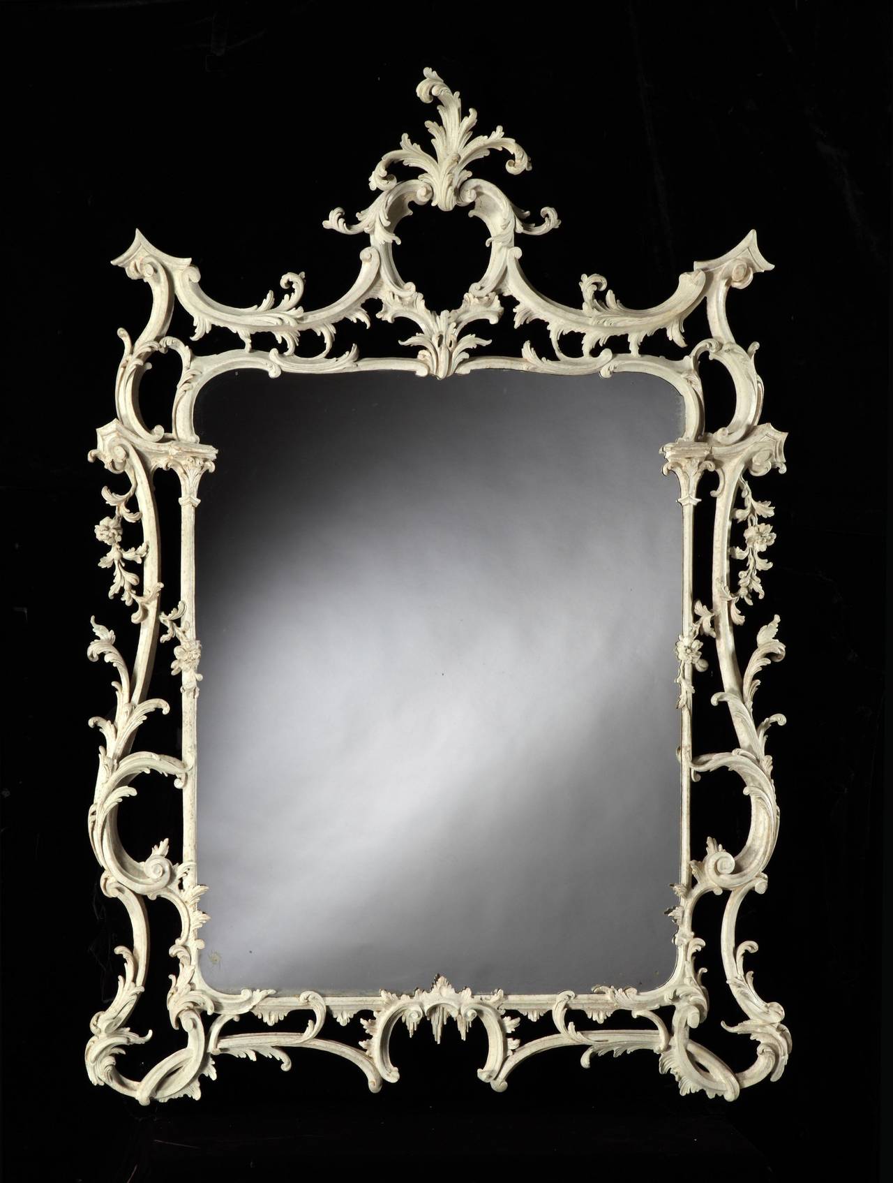 A highly important and extremely rare mid-18th century white painted overmantel mirror retaining most of the original paint surface, attributed to Thomas Chippendale, having a replaced 19th century rectangular mirror plate. The fine quality frame