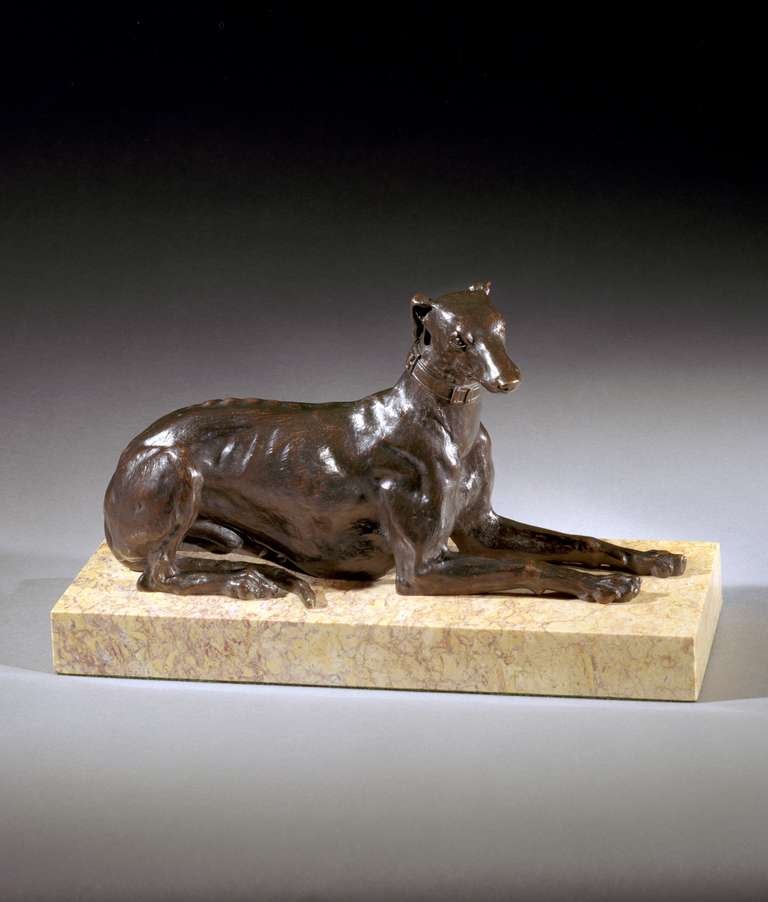 A superb quality early 19th century French bronze greyhound in recumbent position attributed to Antoine Andre Ravrio; on later rectangular marble plinth base.

Note: Ravrio was one of the leading bronze workers of his time in France. This model of