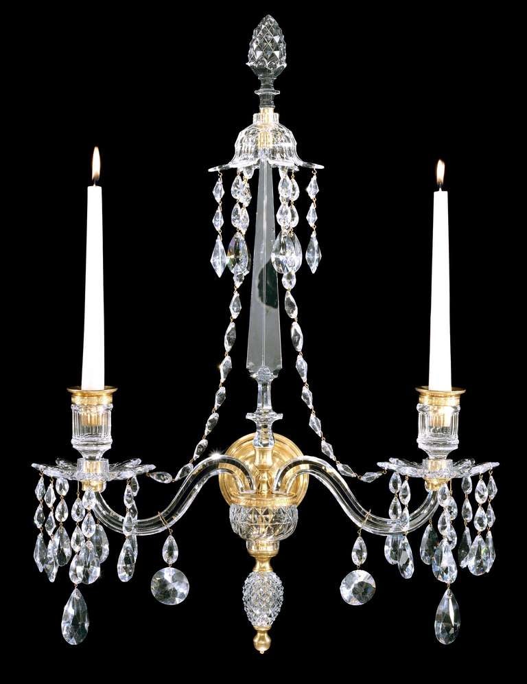 A very rare set of four early 19th century Adam period cut-glass and ormolu wall lights attributed to William Parker, each having a central facetted spine with pineapple finials and canopy below and two scroll arms with candle nozzle and ‘Van Dyck’