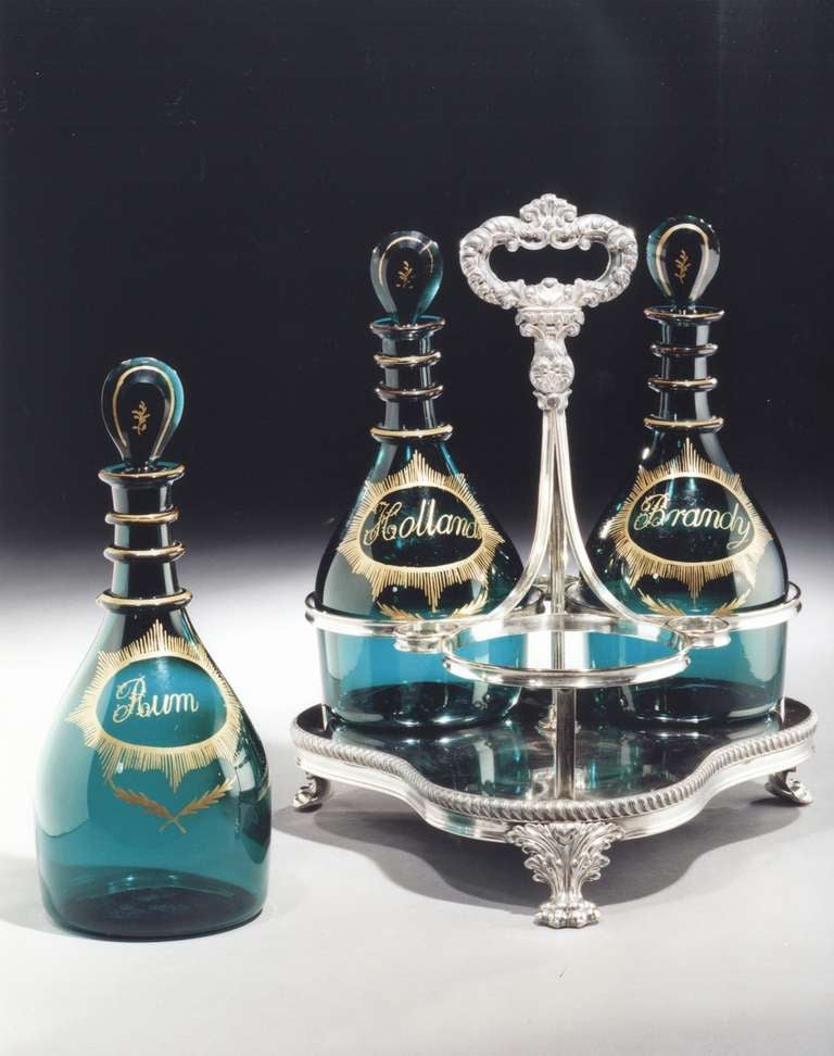 A fine set of three early 19th century green glass decanters of mallett shape with target stoppers having gold labeled with 