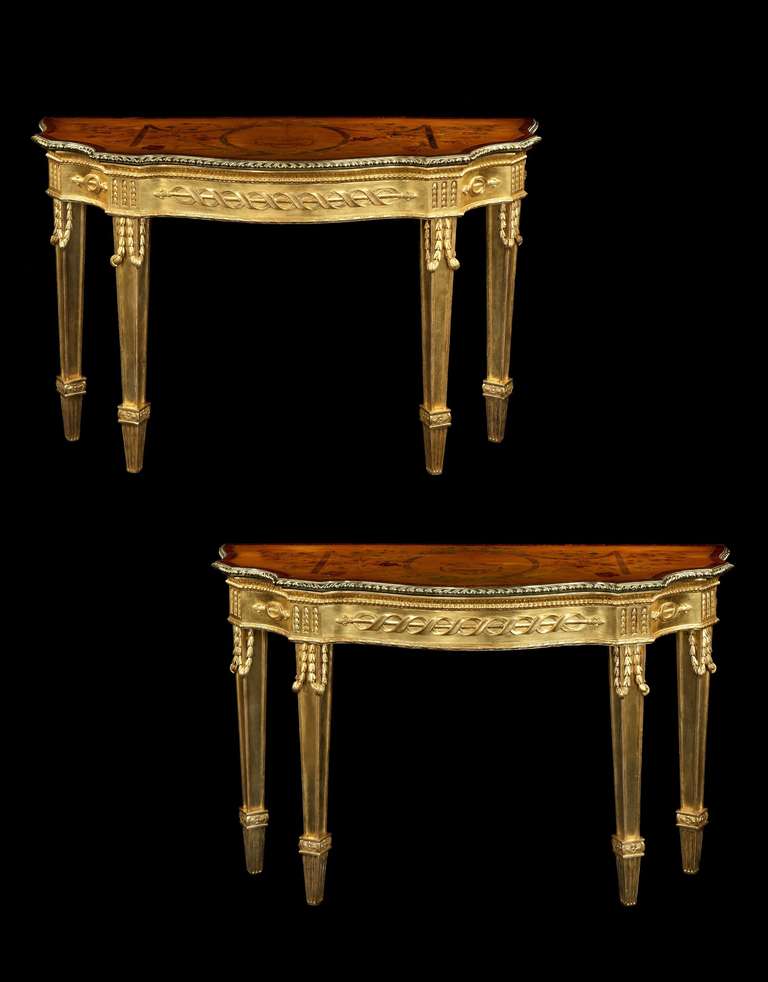A highly important pair of late 18th century Adam period ormolu mounted satinwood marquetry and giltwood side tables attributed to Mayhew and Ince, possibly to a design by James Wyatt , having serpentine shaped tops with finely chased gadrooned