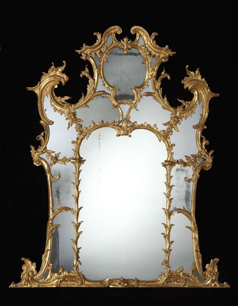 An impressive mid 18th century Chippendale period carved giltwood overmantel mirror, retaining the original gilding and having an 18th century replaced arched centre plate with palm frond carved surround and mostly original shaped border plates,