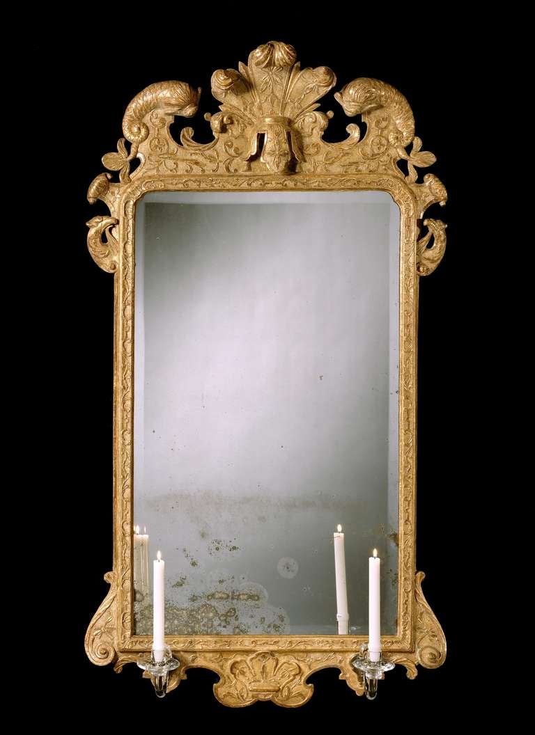 An extremely rare pair of early 18th century carved gesso mirrors, each retaining most of the original gilding and 18th century bevelled mirror plate within an upright rectangular moulded frame decorated with fine leaf carving and strapwork, with