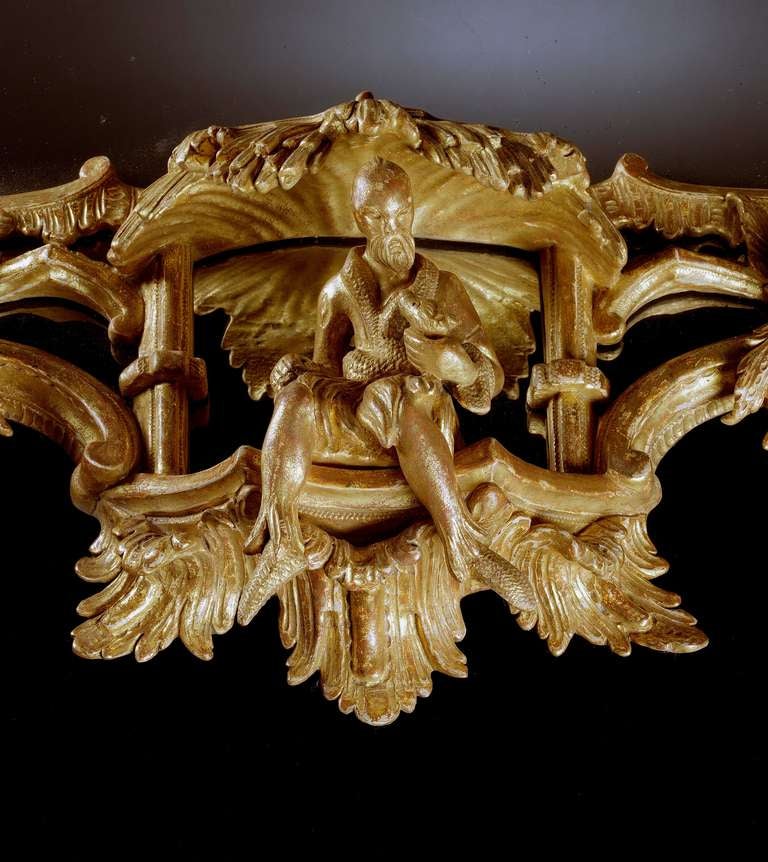 An important mid-18th century Chippendale period carved giltwood rectangular mirror in the Chinese Chippendale taste, retaining the original divided mirror plates within a carved giltwood frame, having a pierced fret gallery cresting on stylized