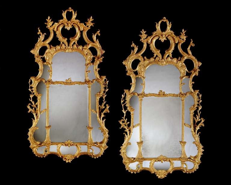 A highly important pair of mid 18th century Chippendale period carved giltwood rectangular border glass mirrors retaining most of the original plates, divided by a fillet supporting opposing carved eagles and having columns either side. The