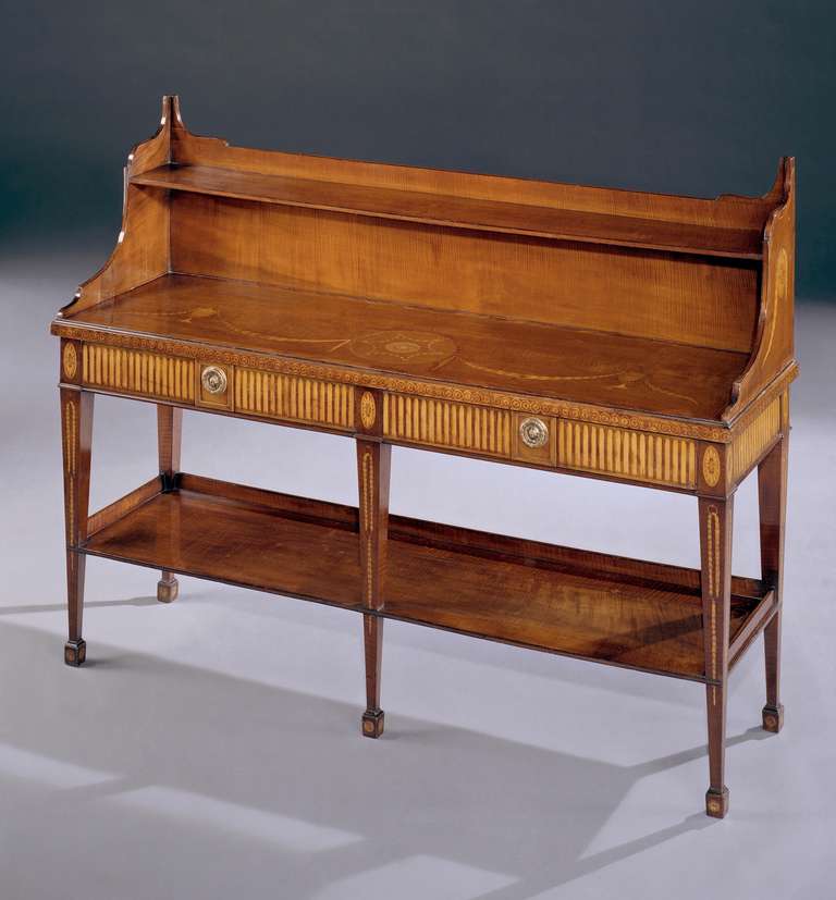 A superb pair of late 18th century side tables having harewood veneered tops with tulipwood crossbanding and ebony and boxwood stringing inlaid with swags of engraved husks and classical urns centred by a rosette. The edge inlaid with a guilloche