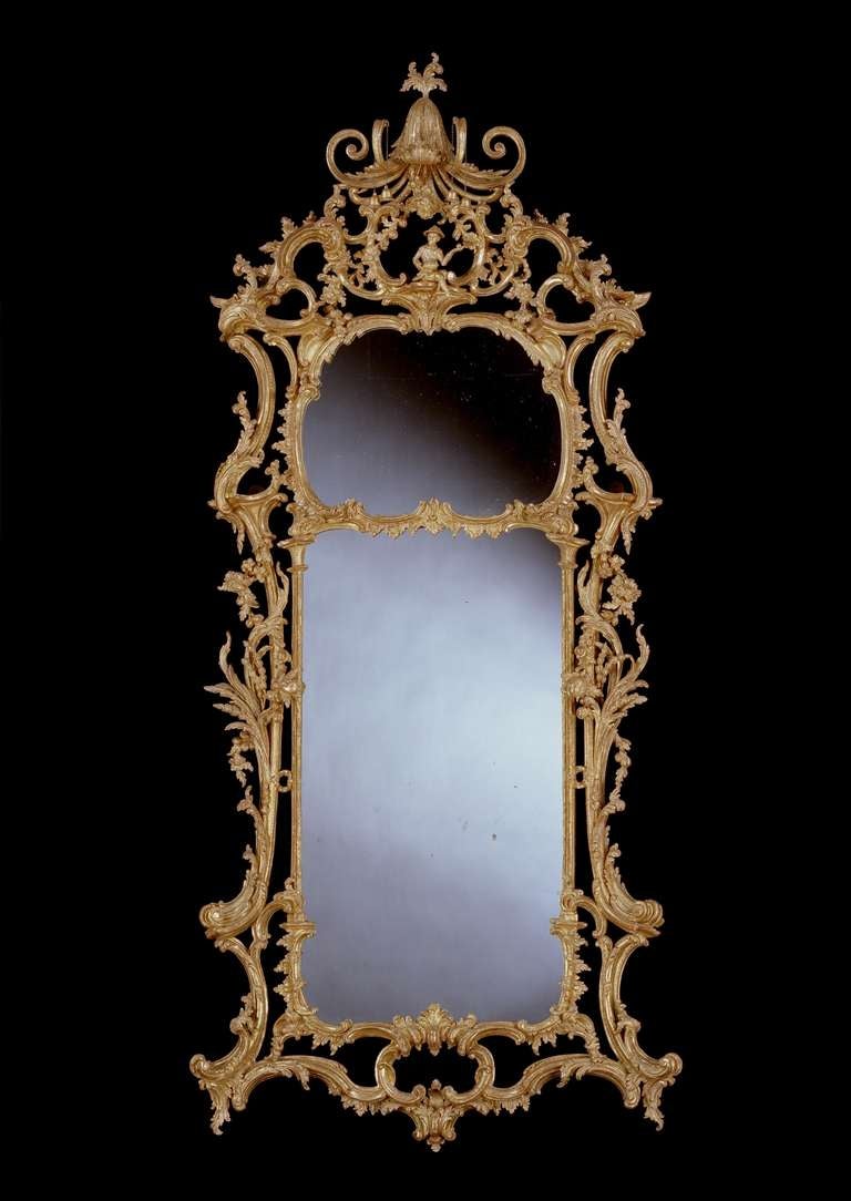 An extremely fine quality and important mid 18th century Chippendale period carved giltwood mirror with the upper arched and lower rectangular replaced 18th century plates divided by a carved foliate fillet, with a pierced frame crisply carved with