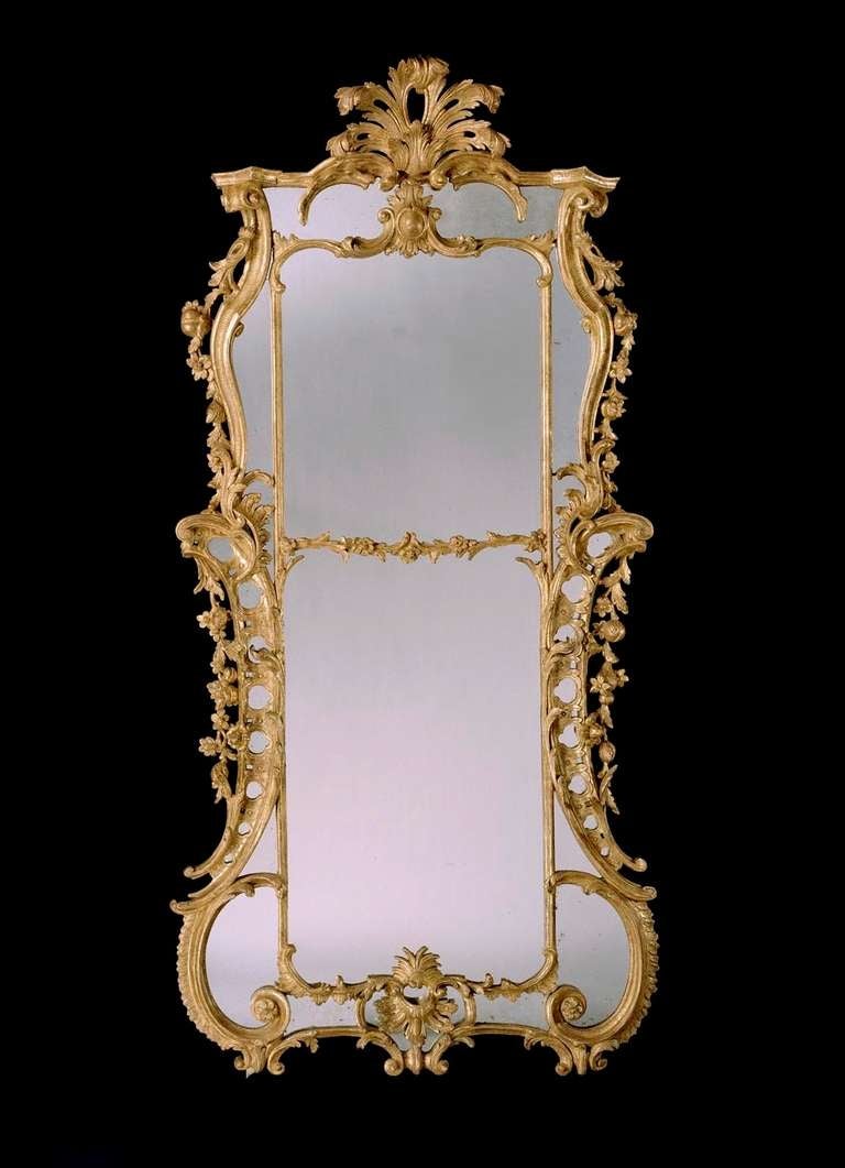 A fine and important pair of mid 18th century carved giltwood border glass mirrors in the manner of William and John Linnell, having 18th century replacement plates divided by a rocaille carved fillet, with straight cresting surmounted by stylized