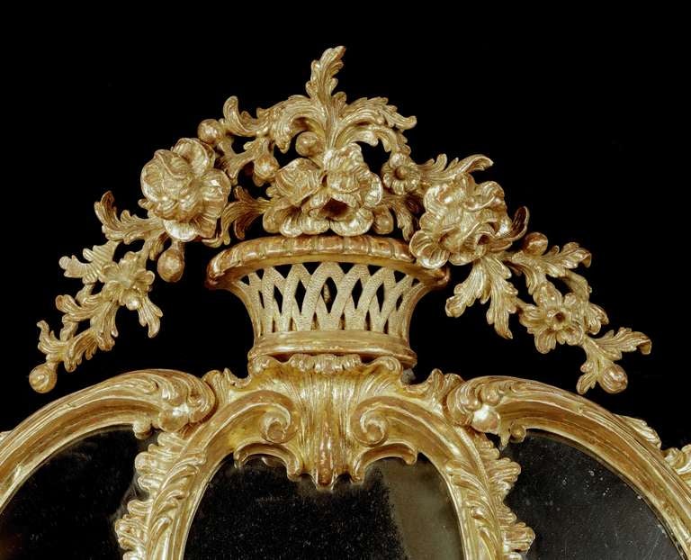 A highly elaborate and most important mid-18th century Chippendale period carved giltwood border glass mirror in the manner of John Linnell, the cartouche shaped frame, with an oval upper plate with a larger replaced 18th century oval plate below,