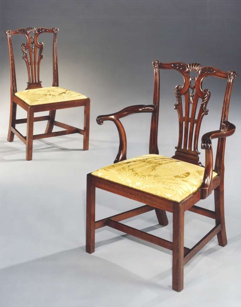 A set of ten mid 18th century Chippendale period carved mahogany dining chairs comprising of eight side chairs and two armchairs, each having a serpentine shaped crest rail joining the moulded uprights and finely carved with acanthus leaf, central