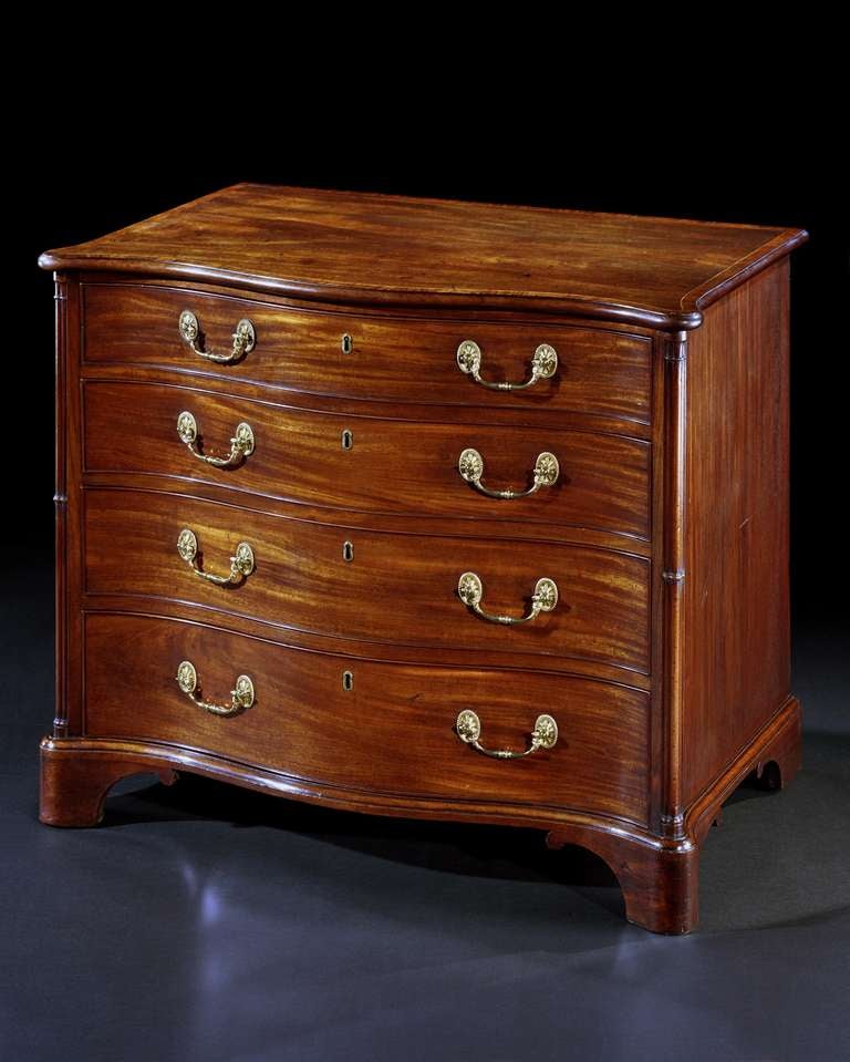 A mid 18th century Chippendale period serpentine mahogany dressing chest, the shaped padouk crossbanded moulded top above a fitted drawer with a green baize-lined slide enclosing various fitted dressing boxes arranged around an adjustable dressing