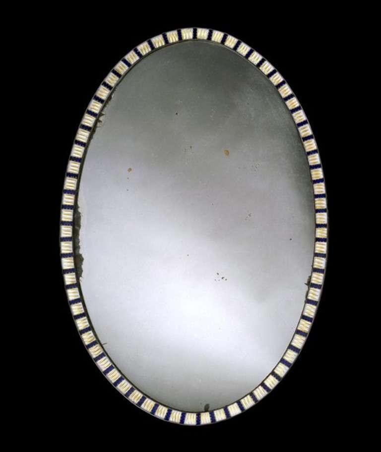 A fine late 18th century Adam period oval mirror, having a replaced 20th century mirror plate within a frame of cobalt blue wavy cut studs interspersed with opaque studs with gilt cut decoration secured by copper bands either side.
