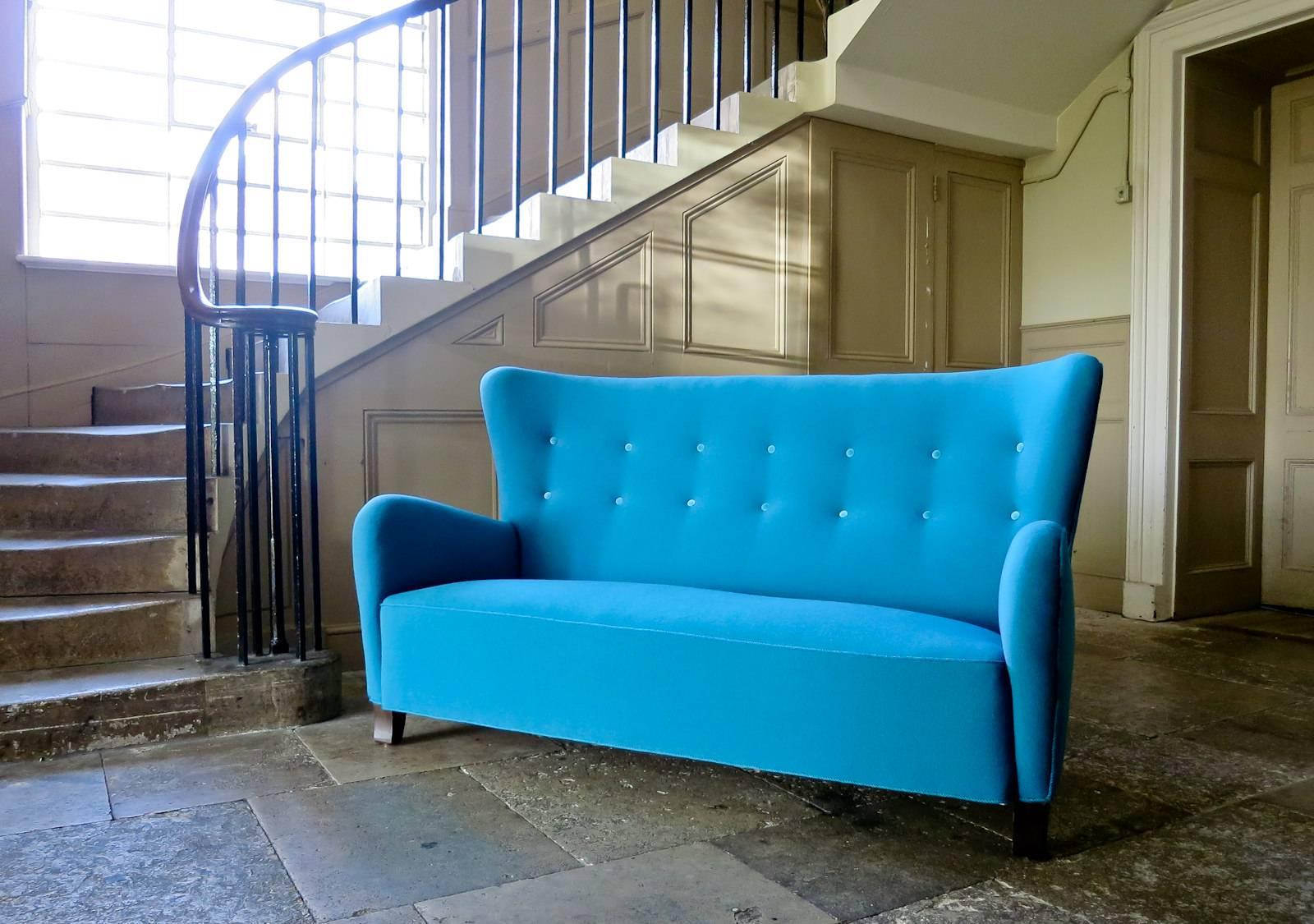 A beautifully designed high back Danish sofa dating from the 1940s. Delicate soft organic curves and lines to this piece, in a rare high back design. Newly upholstered in teal blue wool upholstery with velvet buttons and teal trimmings, all in an