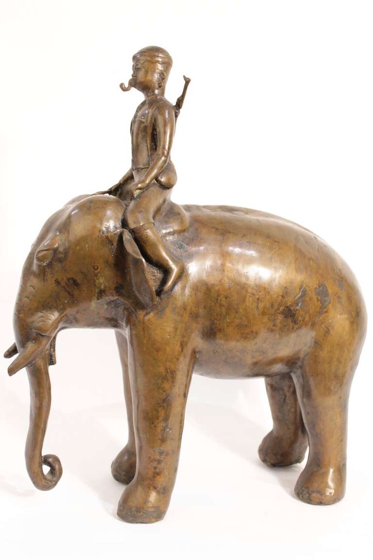Beautiful elephant sculture in bronce with a man standing on his back.