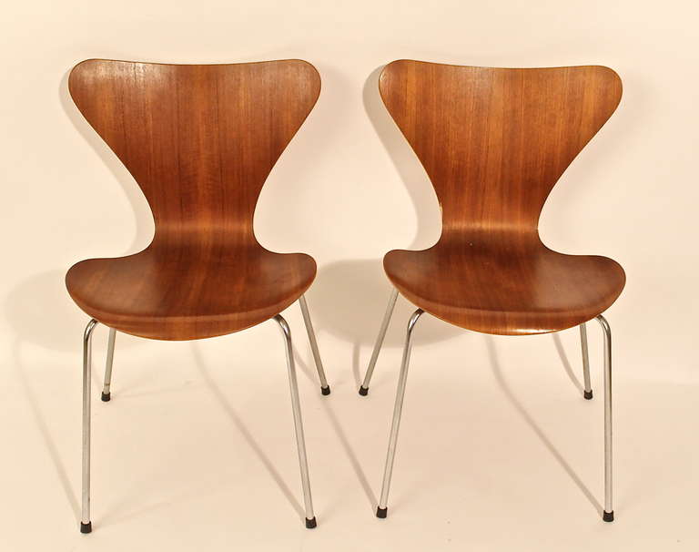Original pair of Fritz Hansen Danish furniture design company chairs on brownwood. The most important 20th century designers as Jacobsen, Wegner or Hein, collaborated on their designs.