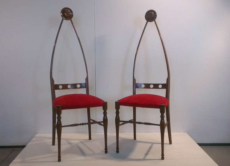 Two chairs with frame in walnut shaped by Neogothic style, seat upholstery in red velvet. 
Italian manufacturing, 1950.