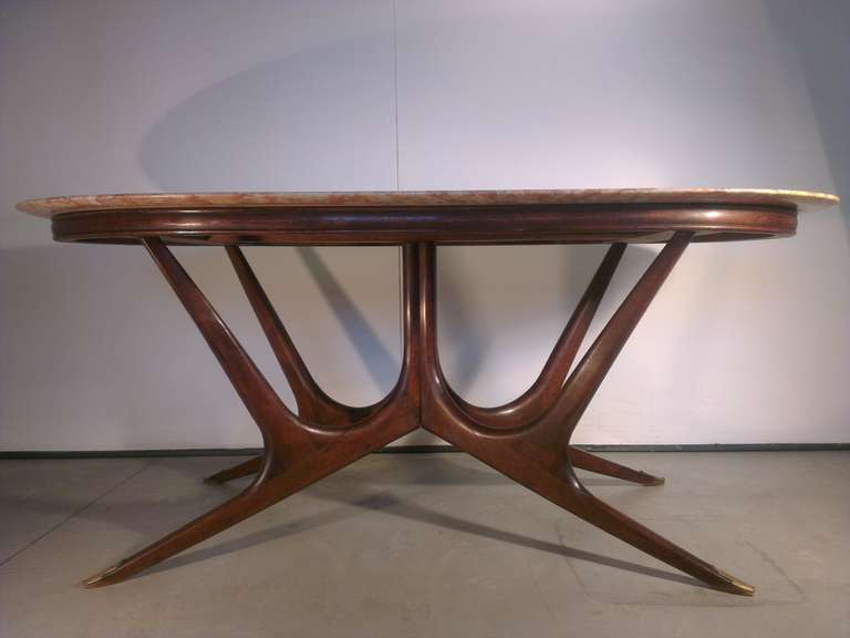 Cesare Lacca table in walnut wood and beautiful fossil marble elliptical, brass leaf on the feet