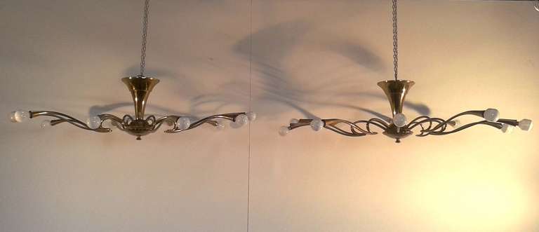 large brass  chandeliers in the shape of spider , ten lights each , brass arm that ends in a  cone shape 
manufacturing by Lumi  about 1950