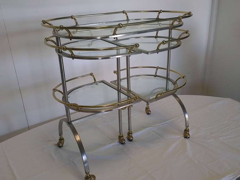 nice trolley with  4 turnable shelves  with its special glasses and oval shape  top , structure in brushed steel and brass