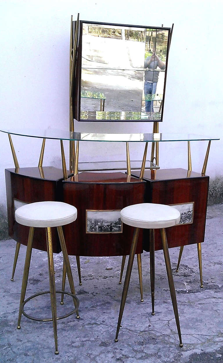 beautiful bar 1950 ,  the cabinet is a rosewood  semicircle with 3 compartments supported by legs made of brass , in the front of them there are 3 antique prints , and a glass shelve as top ,  the bar is composed also by 2 stools,  brass ans