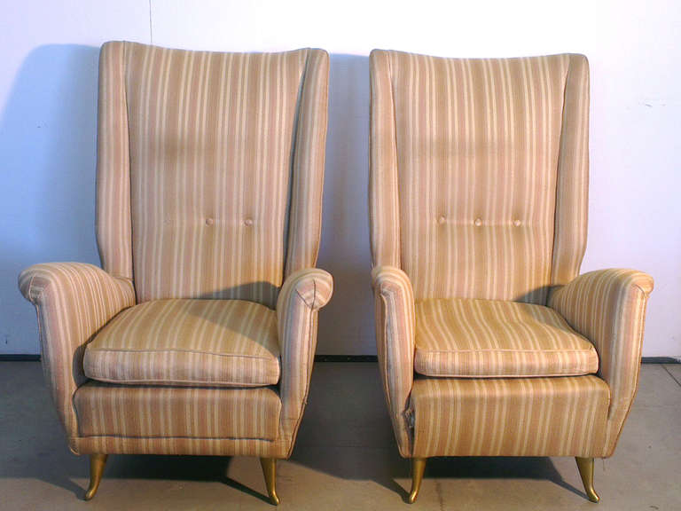 pair of large armchairs with very hight back chair , feet of the chairs brass comma shaped  , produced by ISA - BERGAMO in 1950 , many famous architects designed for ISA also Giò Ponti , infact a similar model was archeived as Ponti in a recent