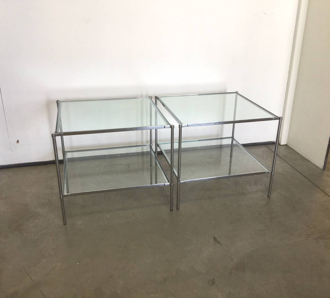 Set composed by four low tables , two bigger ( cm 60 x cm 60 )  and two little ones ( cm 40 x cm 40 ) 
The structure of the table is made of tubular steel with special screw connections 
Two glass shelves each table 
Designed by Luigi Caccia