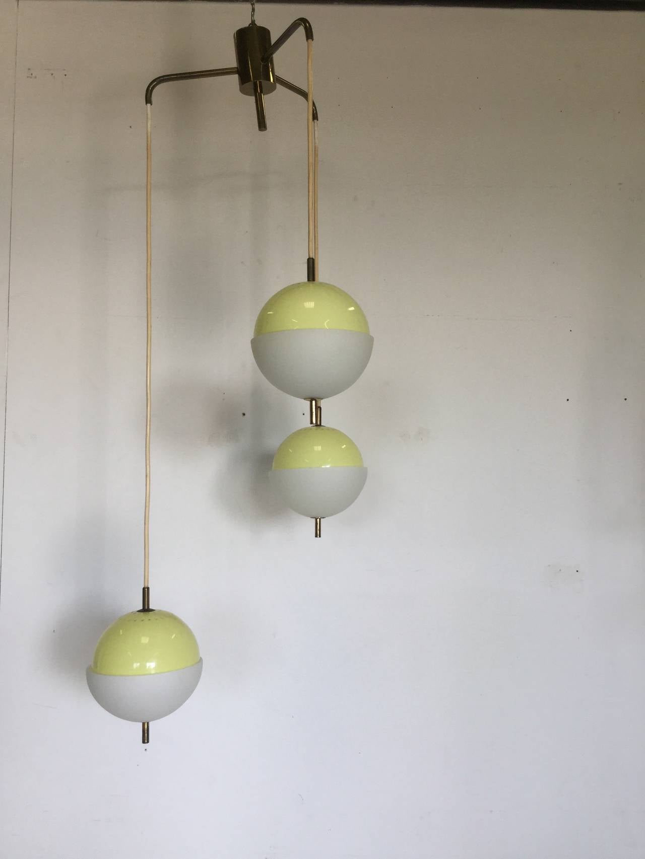 Beautiful chandelier with three globes composed by yellow  plexi and opaline glass , brass elements as ending closure 
Manifactured in 1950  attributed to Arredoluce