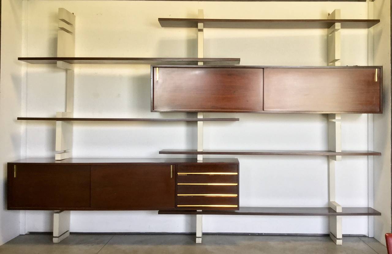 Beautiful bookcase composed by three white lacquered wood uprights on which support shelves and 2 furniture , brass fixtures 
It was designed in 1960 by a company in Turin 