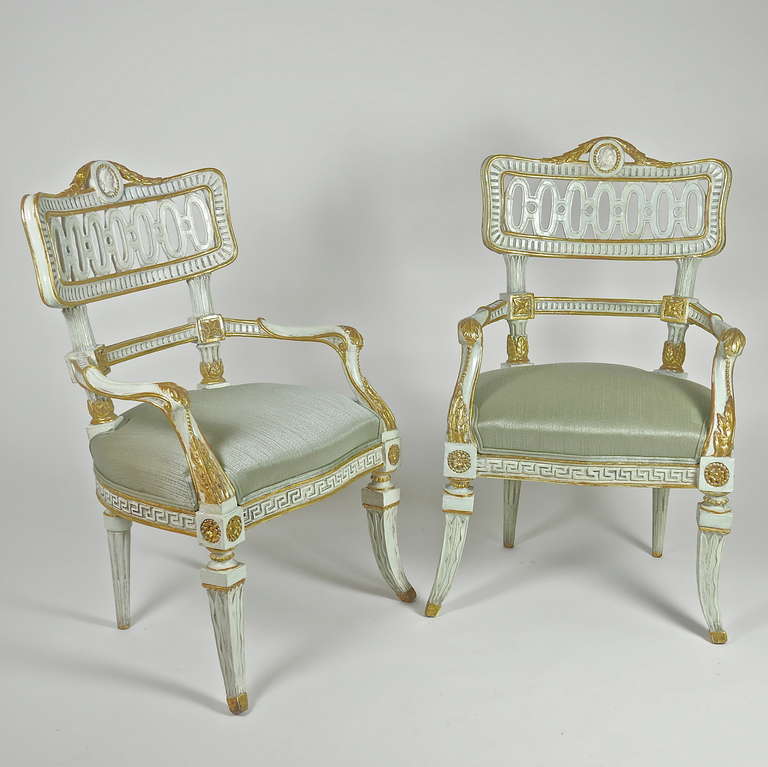 A pair of Italian 18th century painted and parcel-gilt Fauteuils of unusual and elaborate carving. A bowed and pierced carved back, with guilloche carving and a fluted frame, cresting centered by a plaster cast profile medallion of a Roman emperor