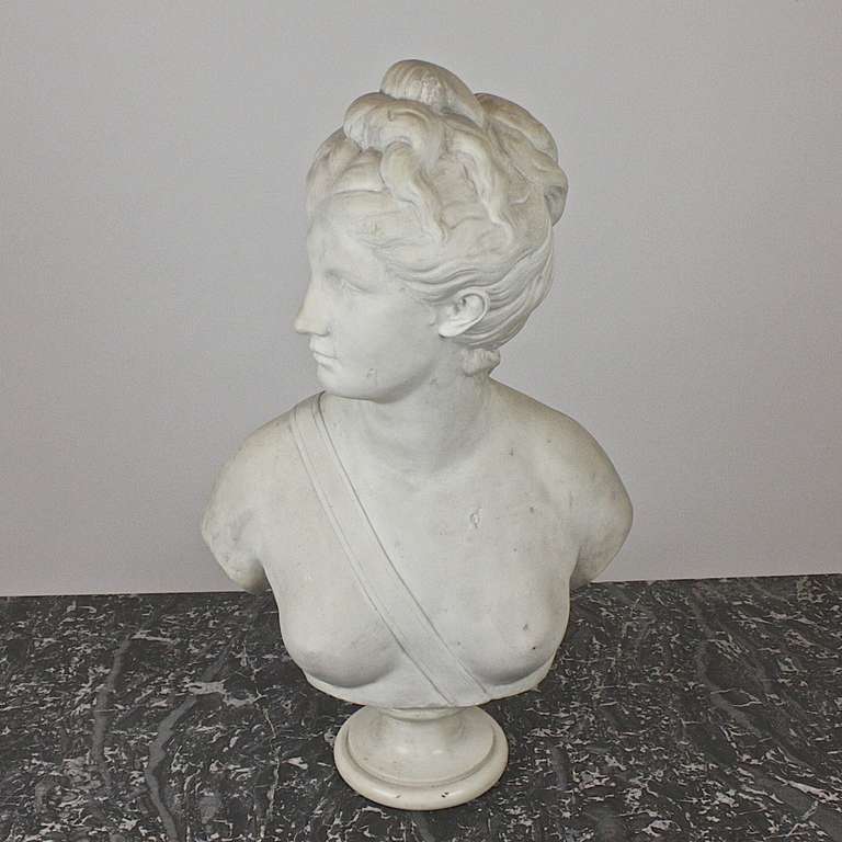 The marble bust depicts the goddess of Diana, a same size marble copy (without socle) of the original marble bust by Jean-Antoine Houdon (1741-1828) from 1778. The original belongs to the National Gallery of Art Washington (inventory number: