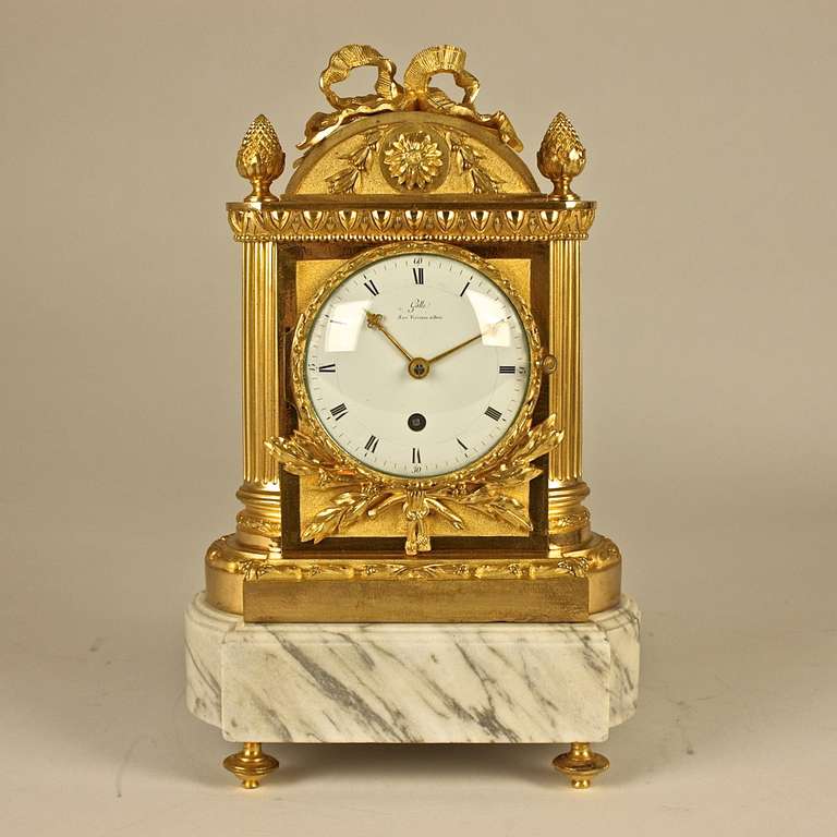 Empire mantel clock, the enamel dial within a finely cast and chased gilt bronze architectural case with  decorative motifs such as fluted columns, pine cones, flowers and ribbon bow. 
The dial signed Galle rue Vivienne in Paris. Gerard-Jean Galle
